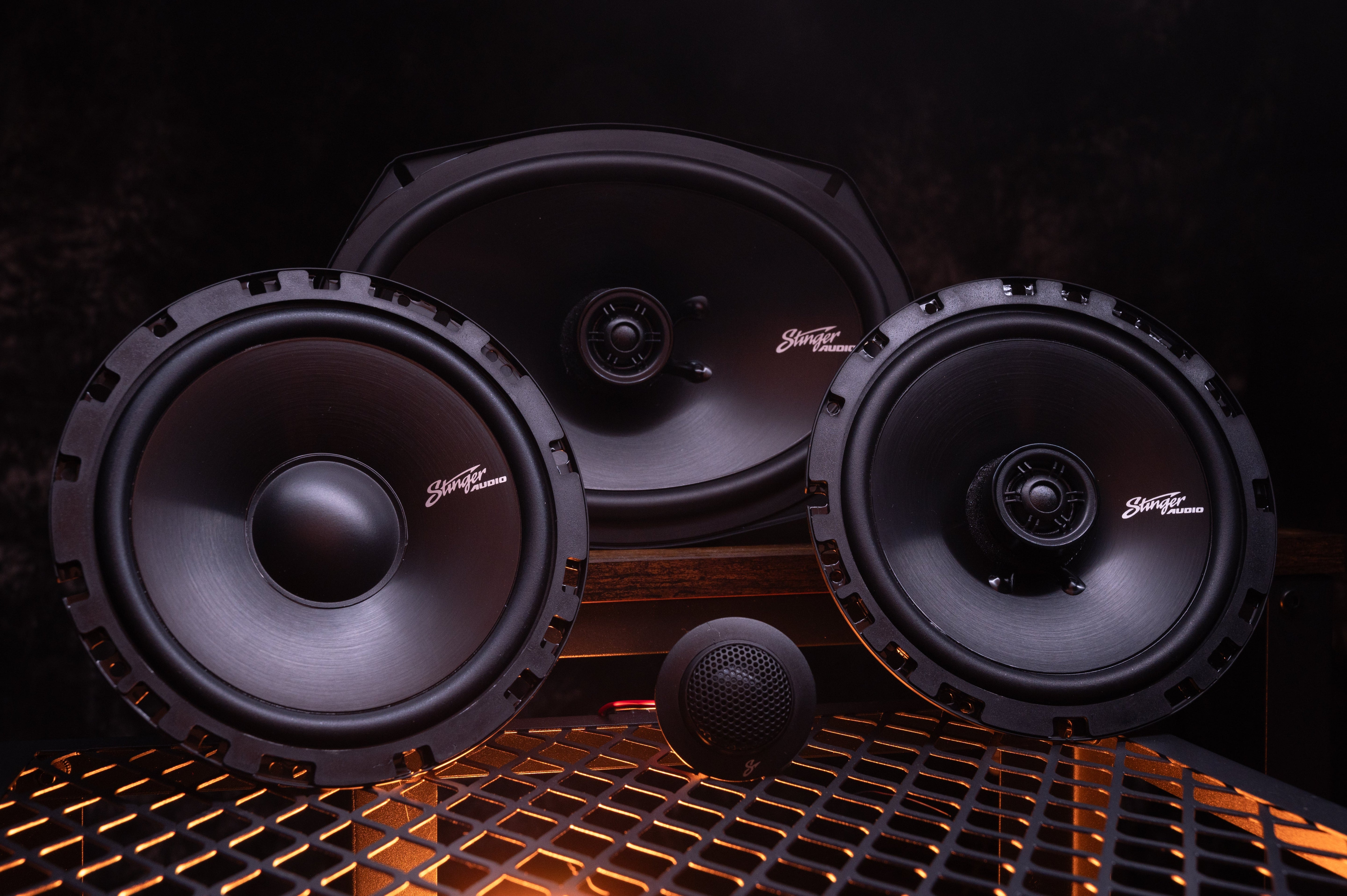 Hero image of three Stinger Audio speakers including two coaxial and one component speakers with one tweeter in the middle