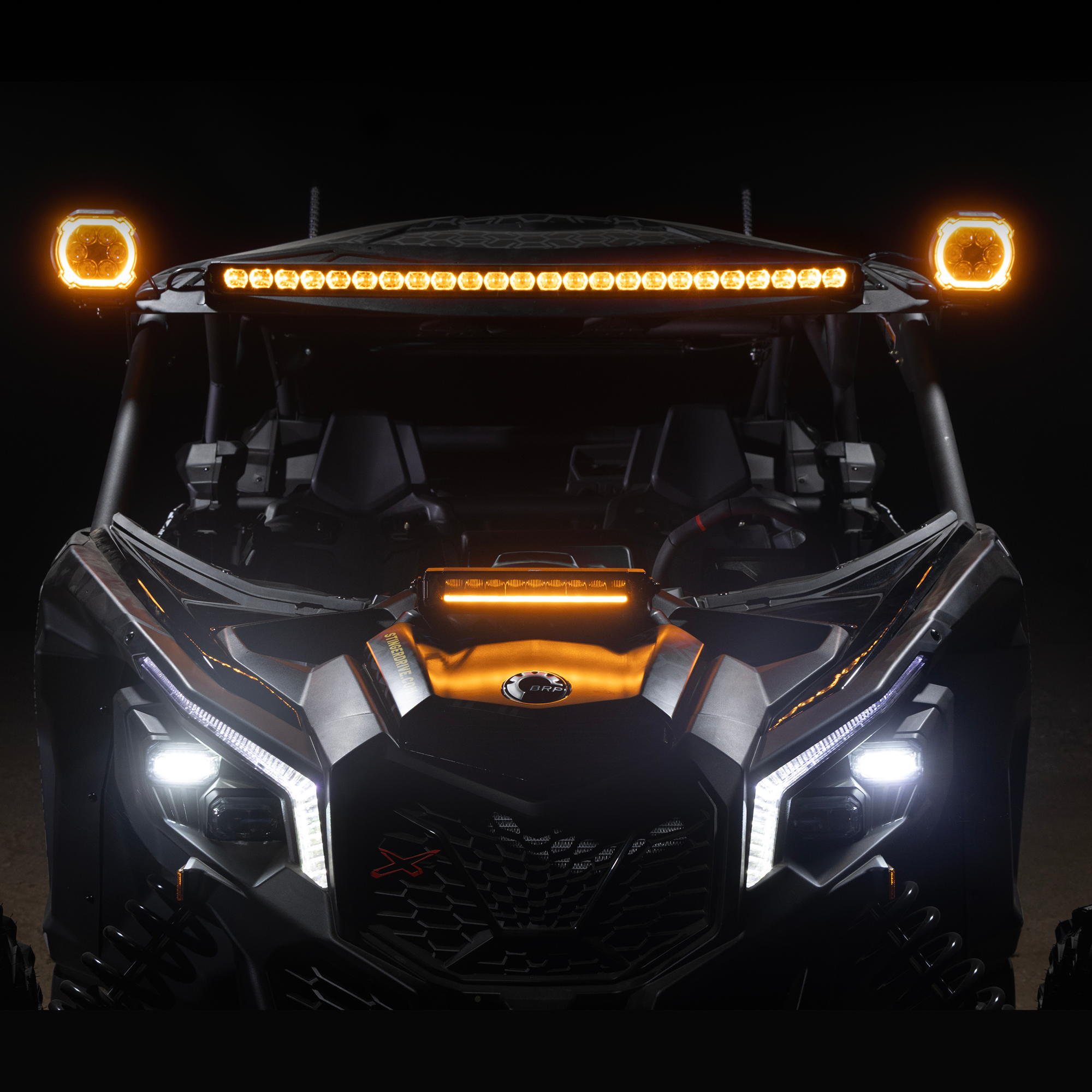 Front view of an off-road vehicle with illuminated lights on a dark background