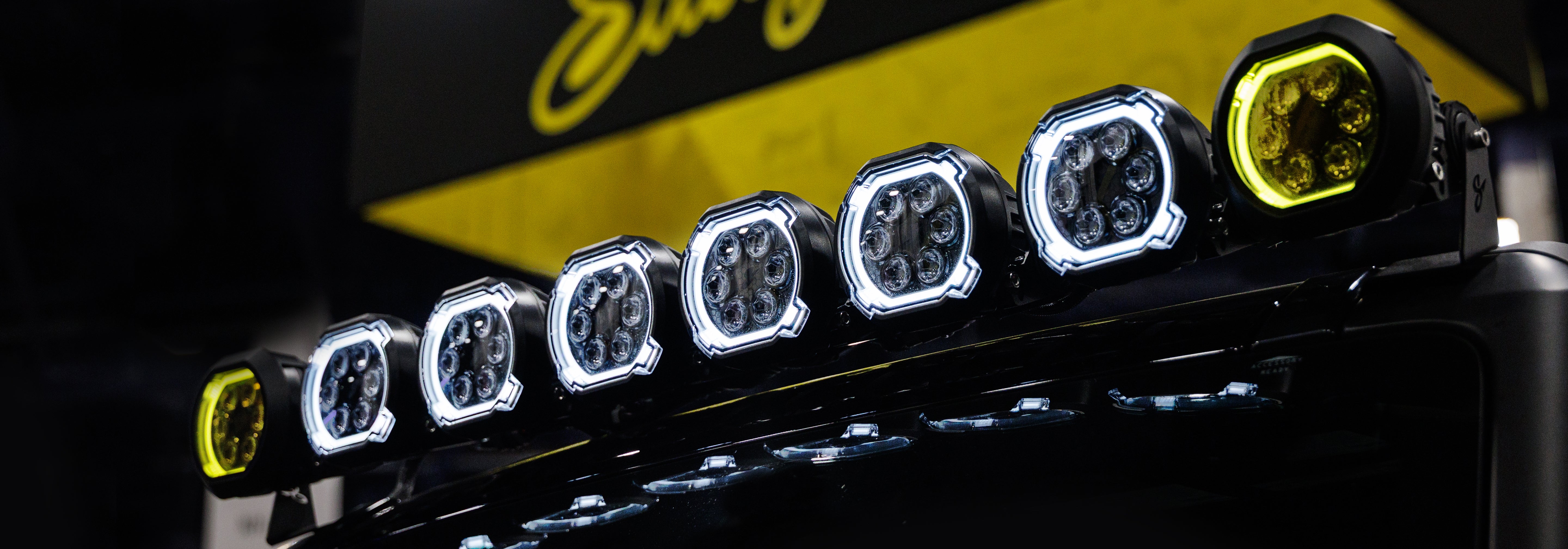 Close-up of a motorcycle headlight with multiple lights on a dark background