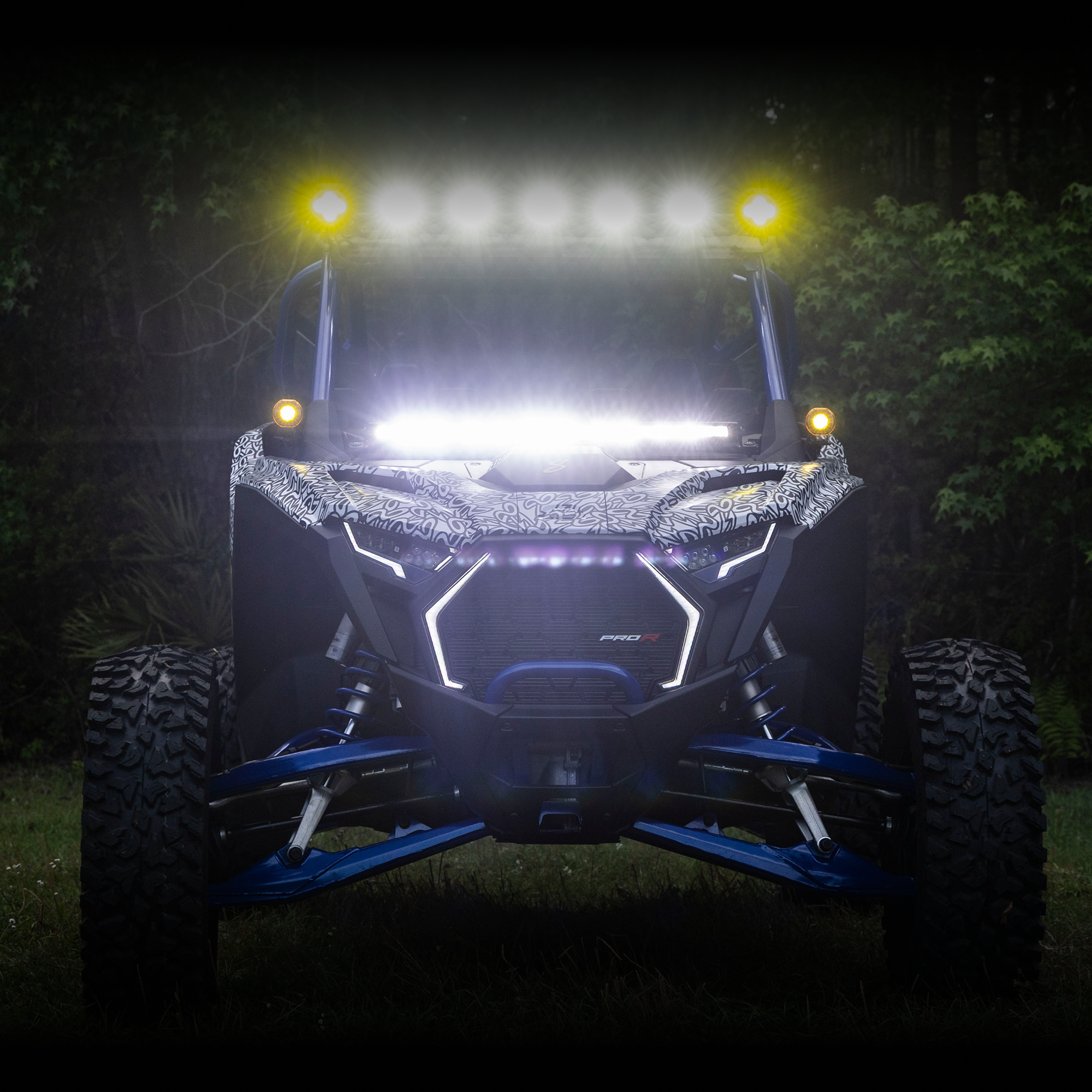 Front view of an off-road vehicle with illuminated lights at night.