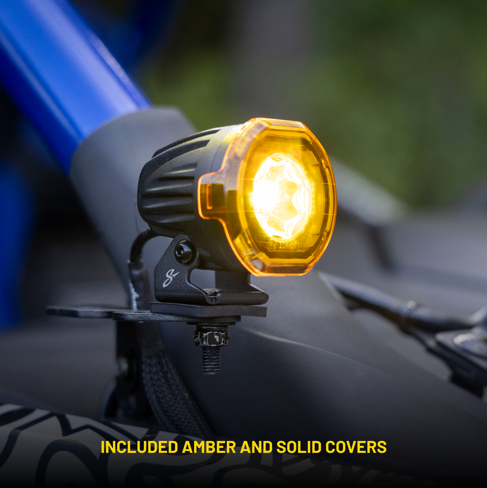 Round LED auxiliary light with amber cover mounted on a vehicle frame