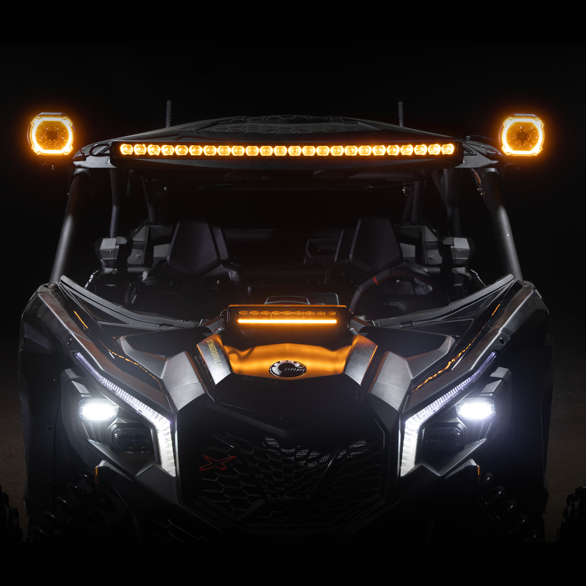 Front view of a black off road vehicle with illuminated amber roof lights and white headlights