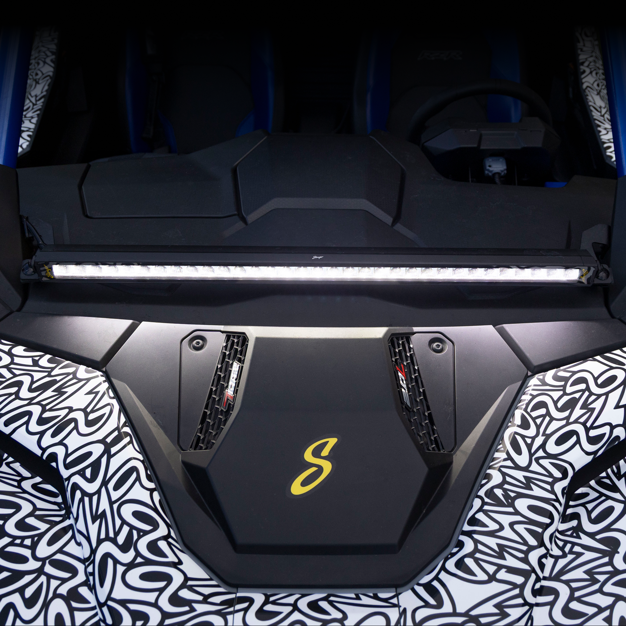 Close-up of a car's front grille with a brand logo, featuring a dark background.