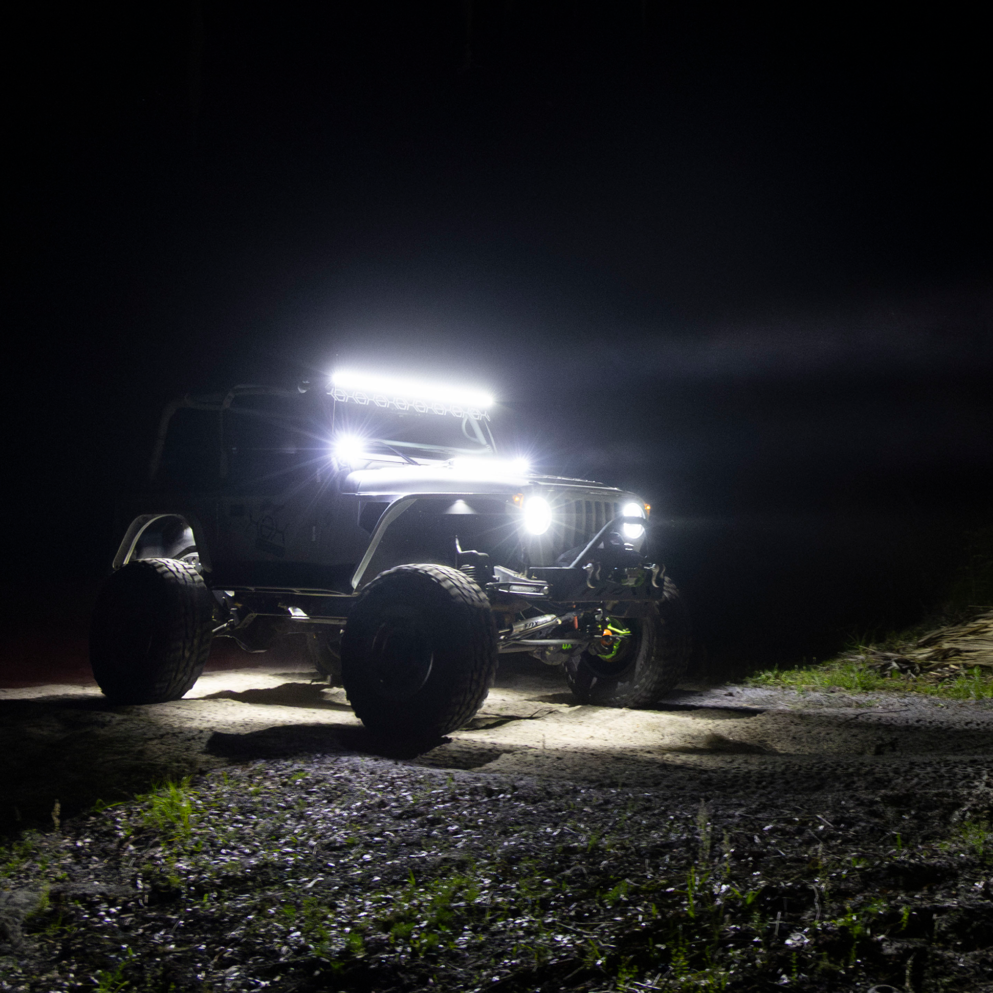 Off-road vehicle with large lights on a dark road