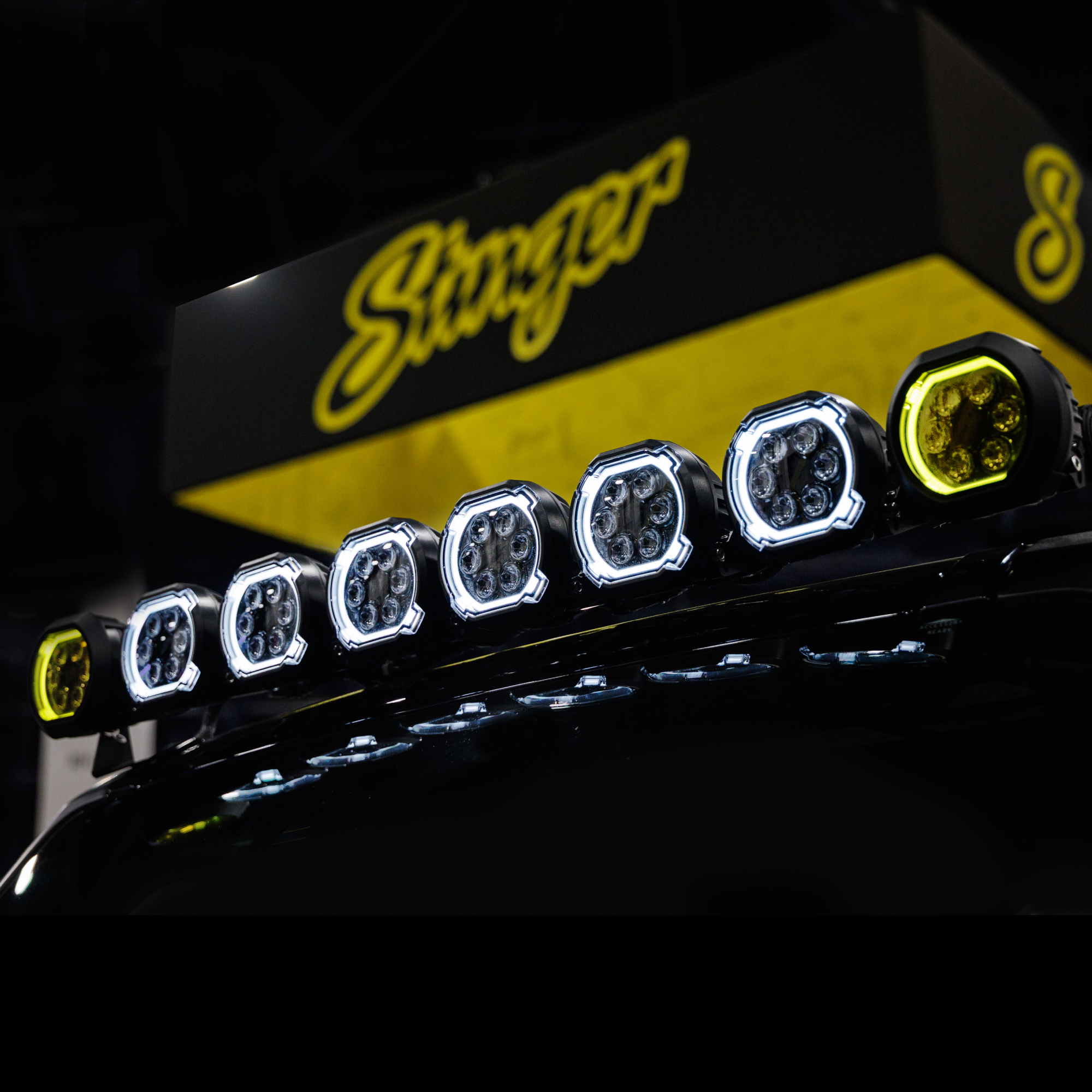 Row of circular LED off road lights mounted on a vehicle roof with Stinger branding in the background