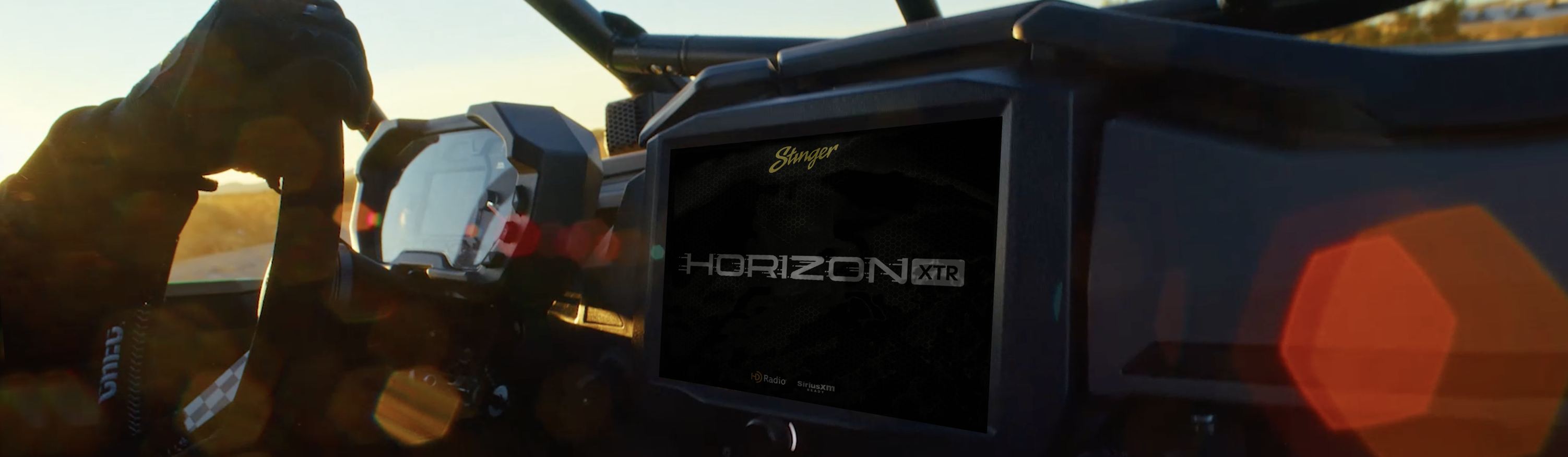 Person driving a powersports vehicle with a HORIZON XTR multi-function display installed on the dash.