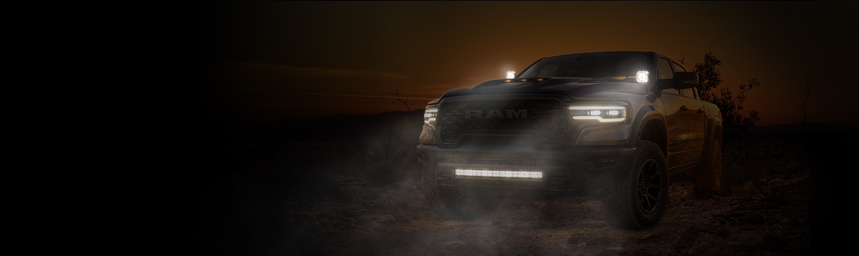 Dark SUV driving on a road at night with headlights on