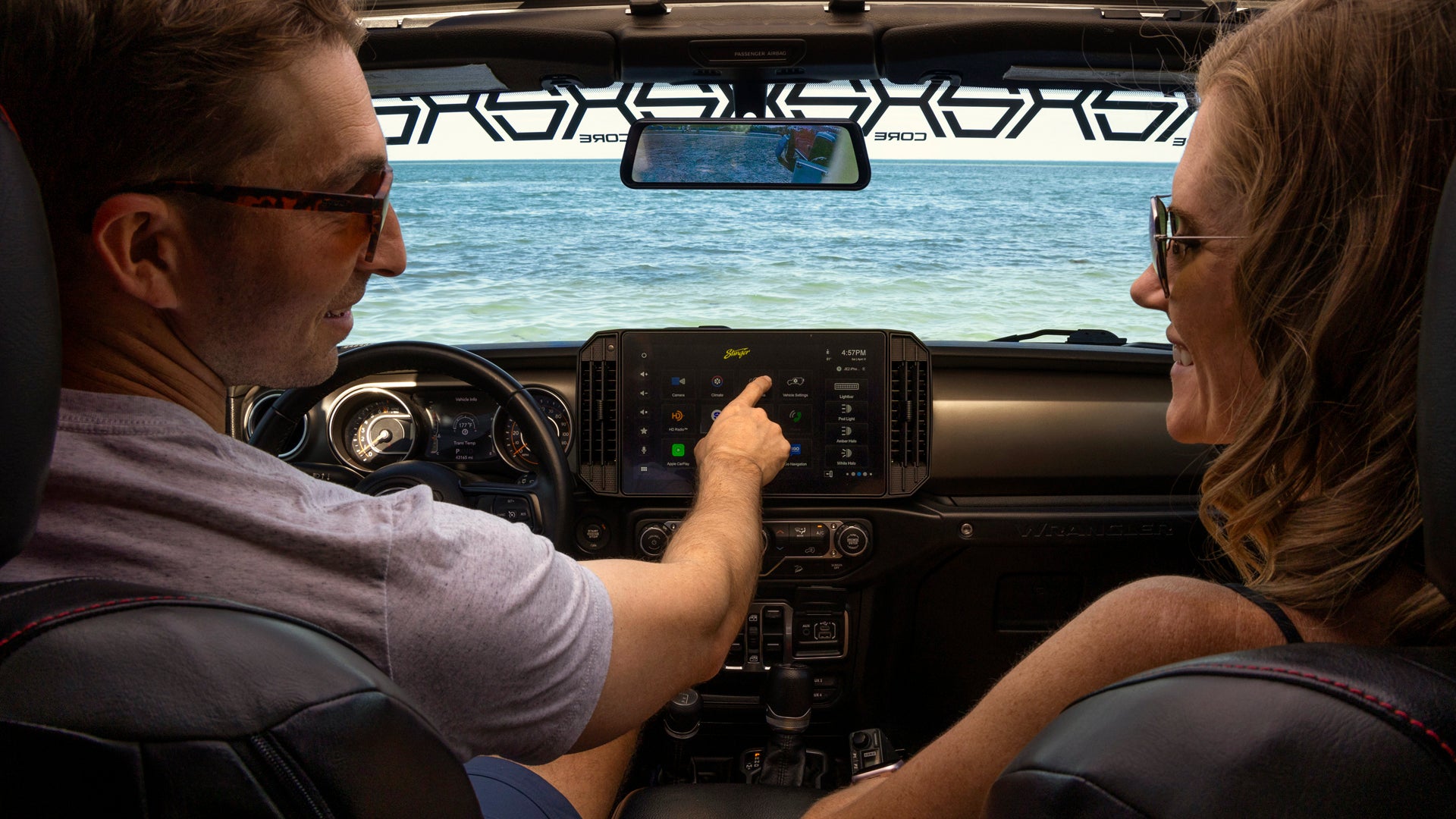 Two people inside a futuristic vehicle interior with digital displays.