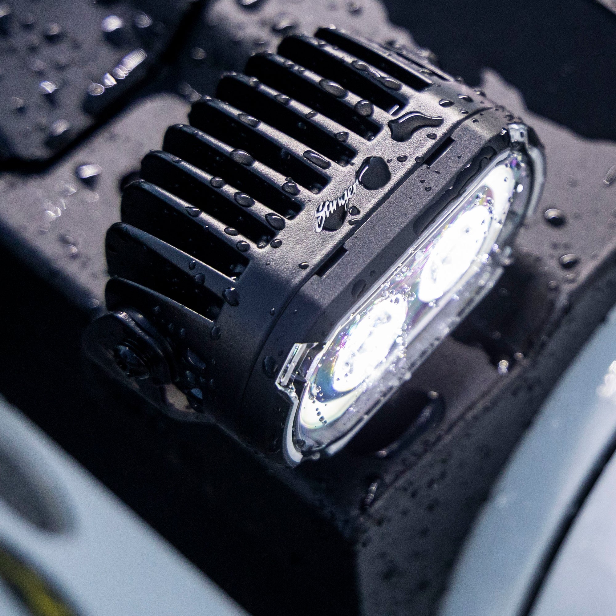 Black Stinger LED off road light with water droplets on the housing