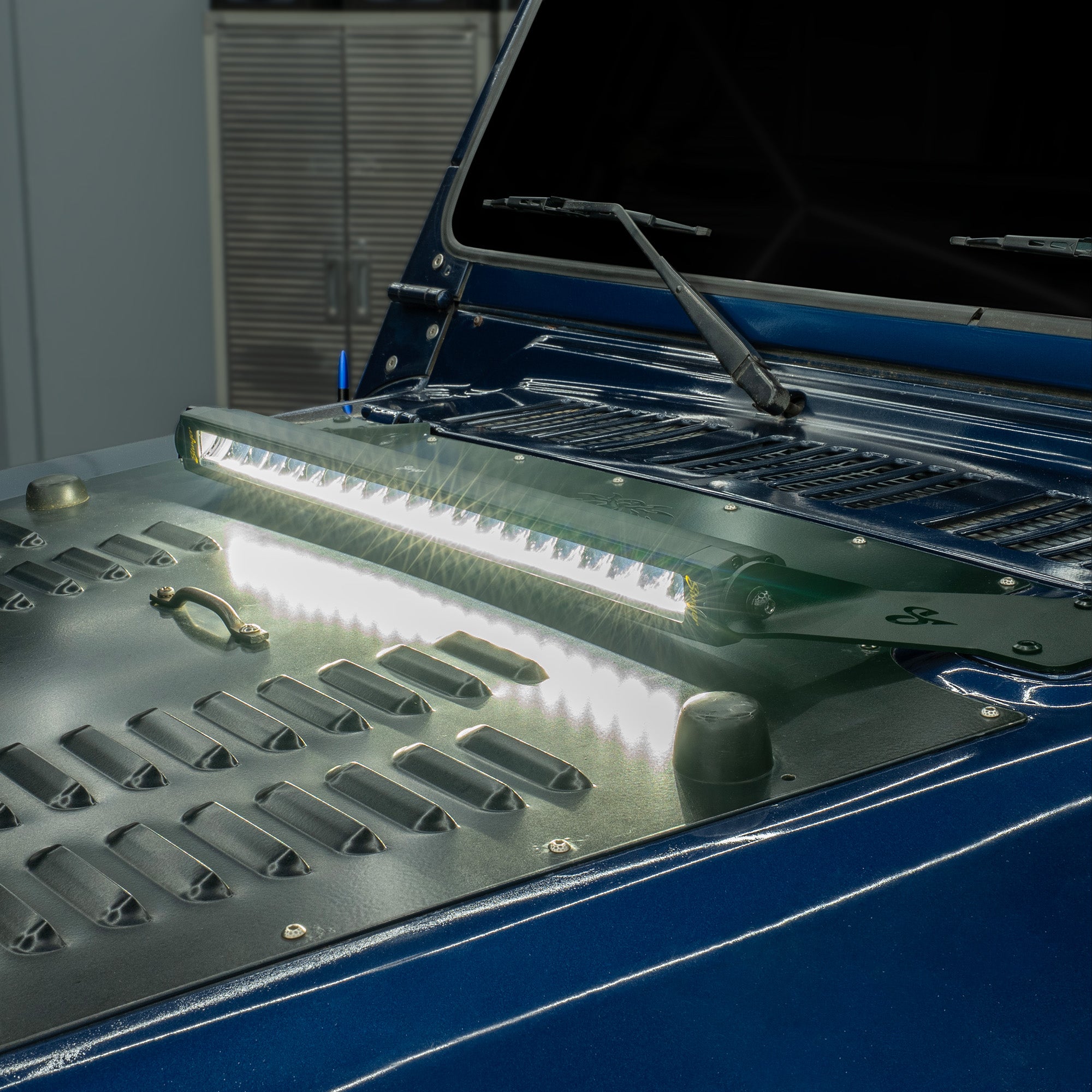 Stinger LED light bar mounted on a blue vehicle hood