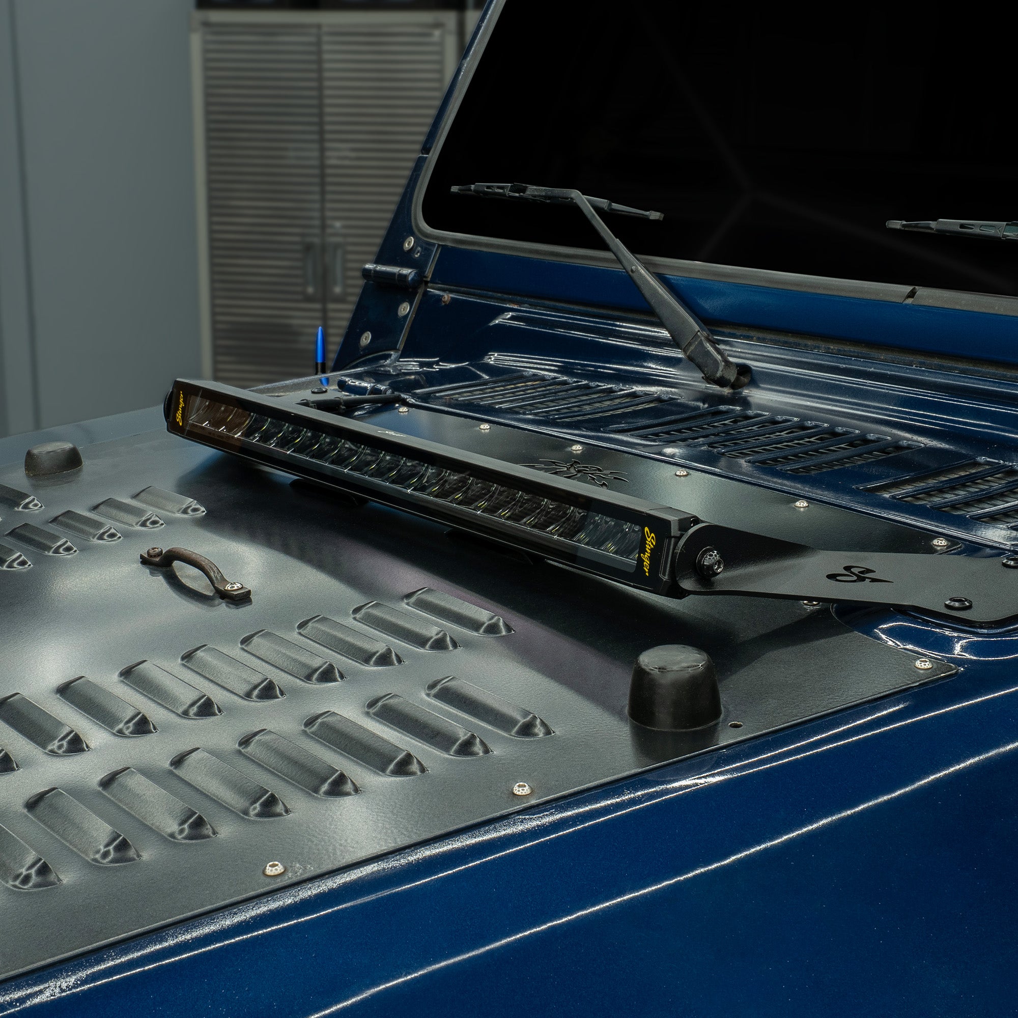 Stinger LED light bar mounted on a blue vehicle hood