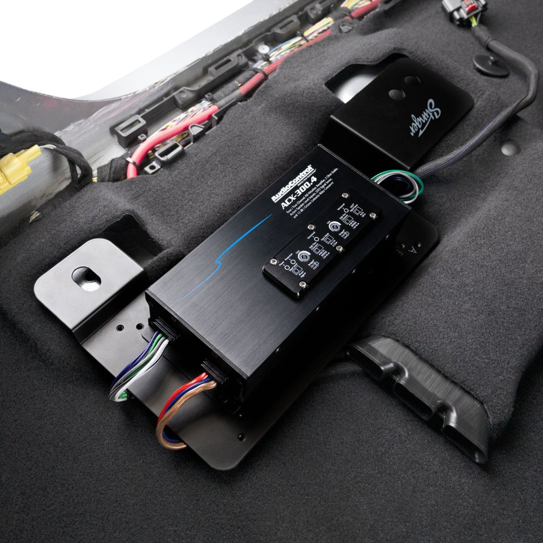 AudioControl ACX-300.4 amplifier mounted on a vehicle carpet panel with wiring