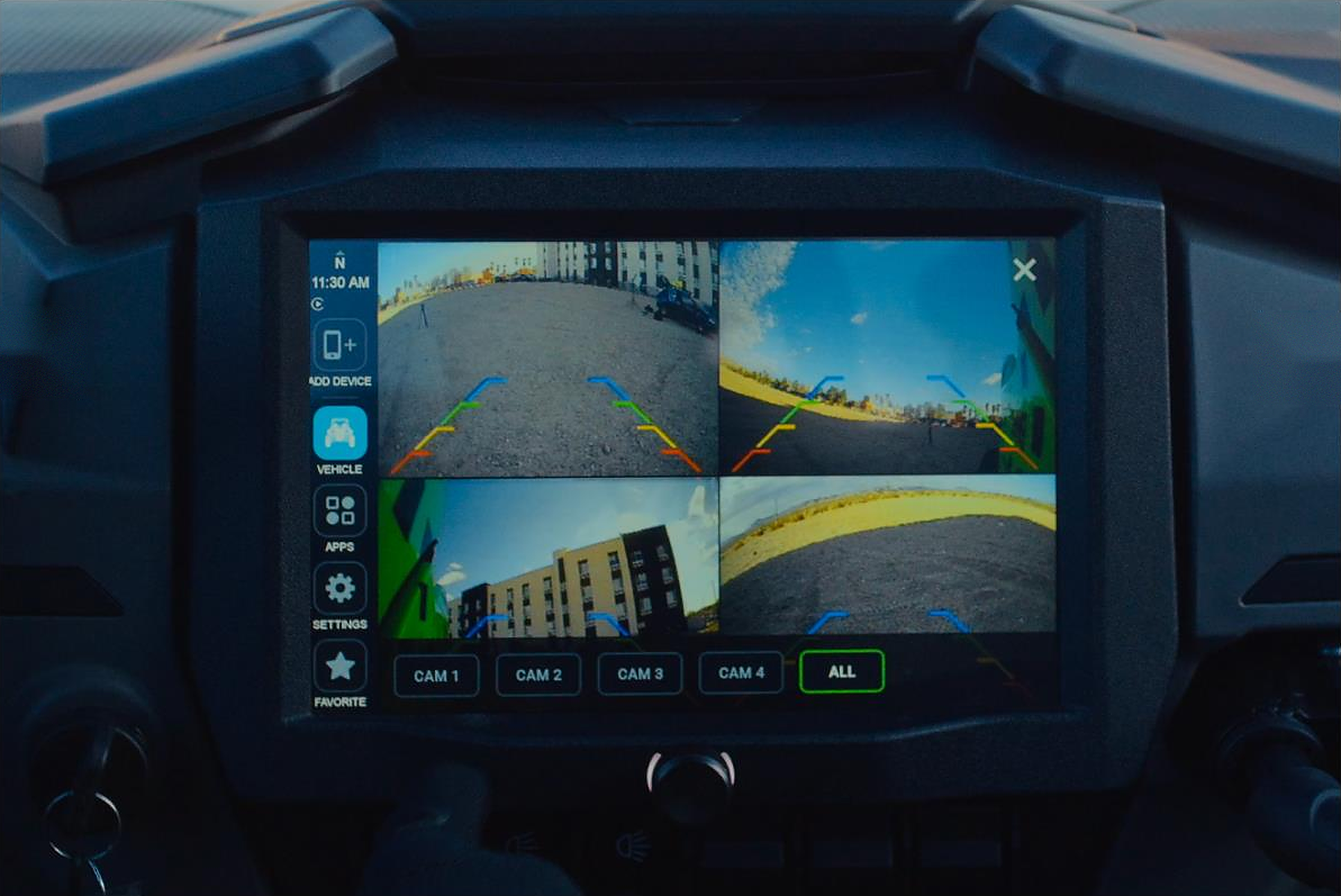 Vehicle dashboard display showing a four camera split screen view