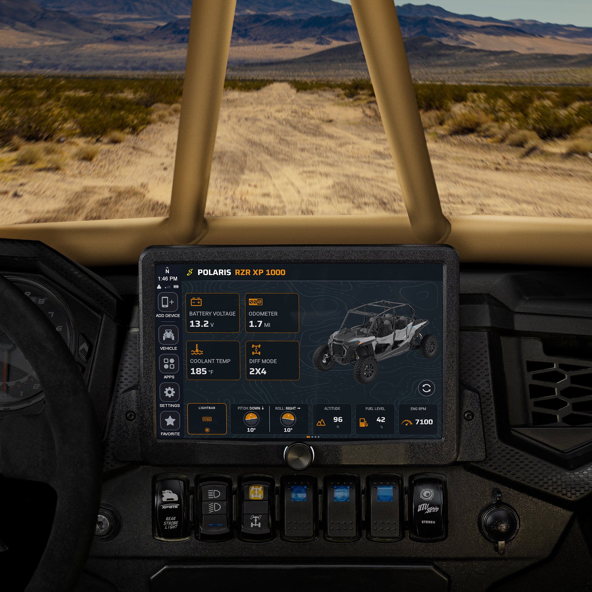 A digital dashboard display mounted on the console of an off-road vehicle, showing vehicle settings and a Polaris XP 1000 quad bike graphic. The vehicle is positioned inside a desert landscape with mountains in the background.