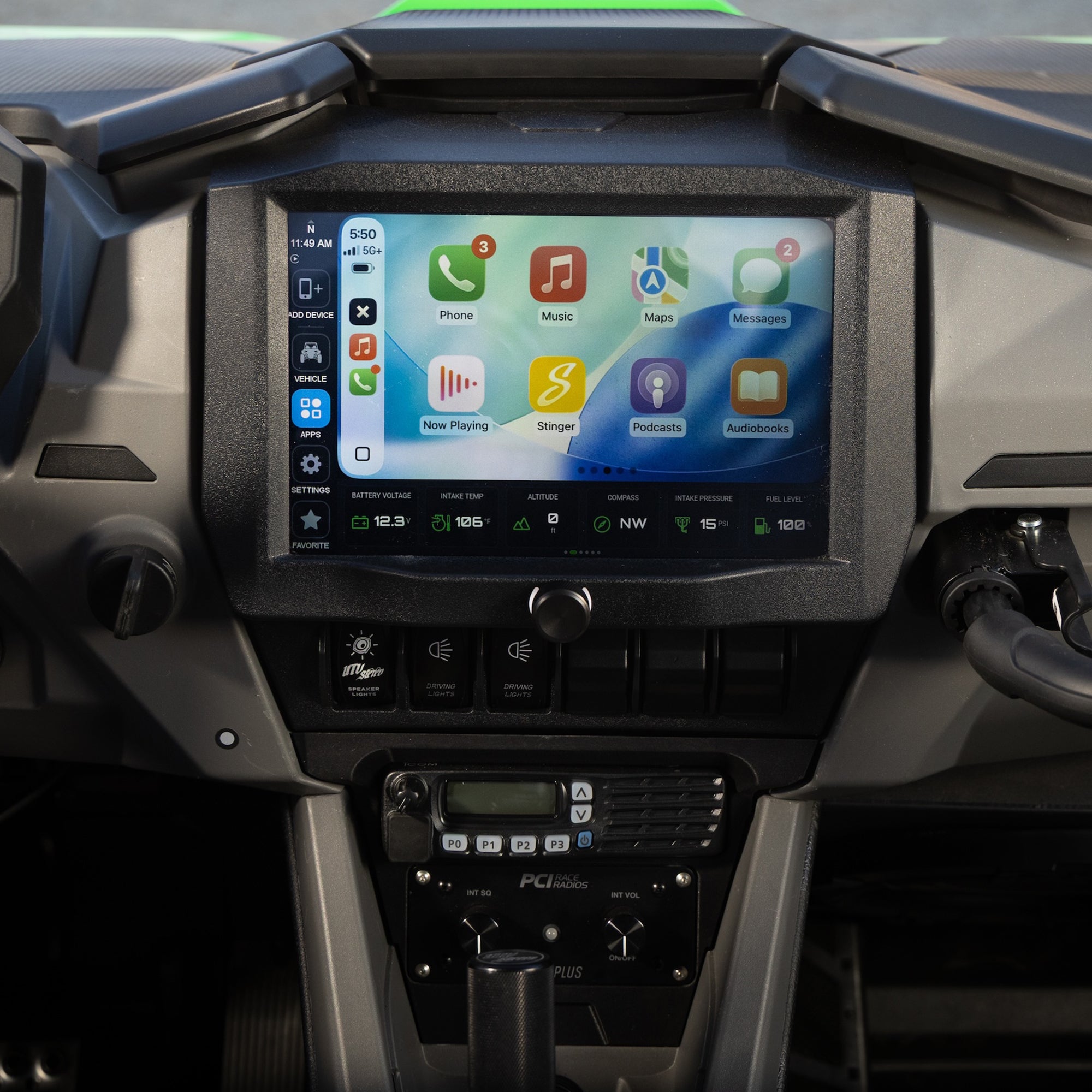 A car dashboard with a large touchscreen display showing an Apple CarPlay interface, mounted above the climate controls and gear shift selector.